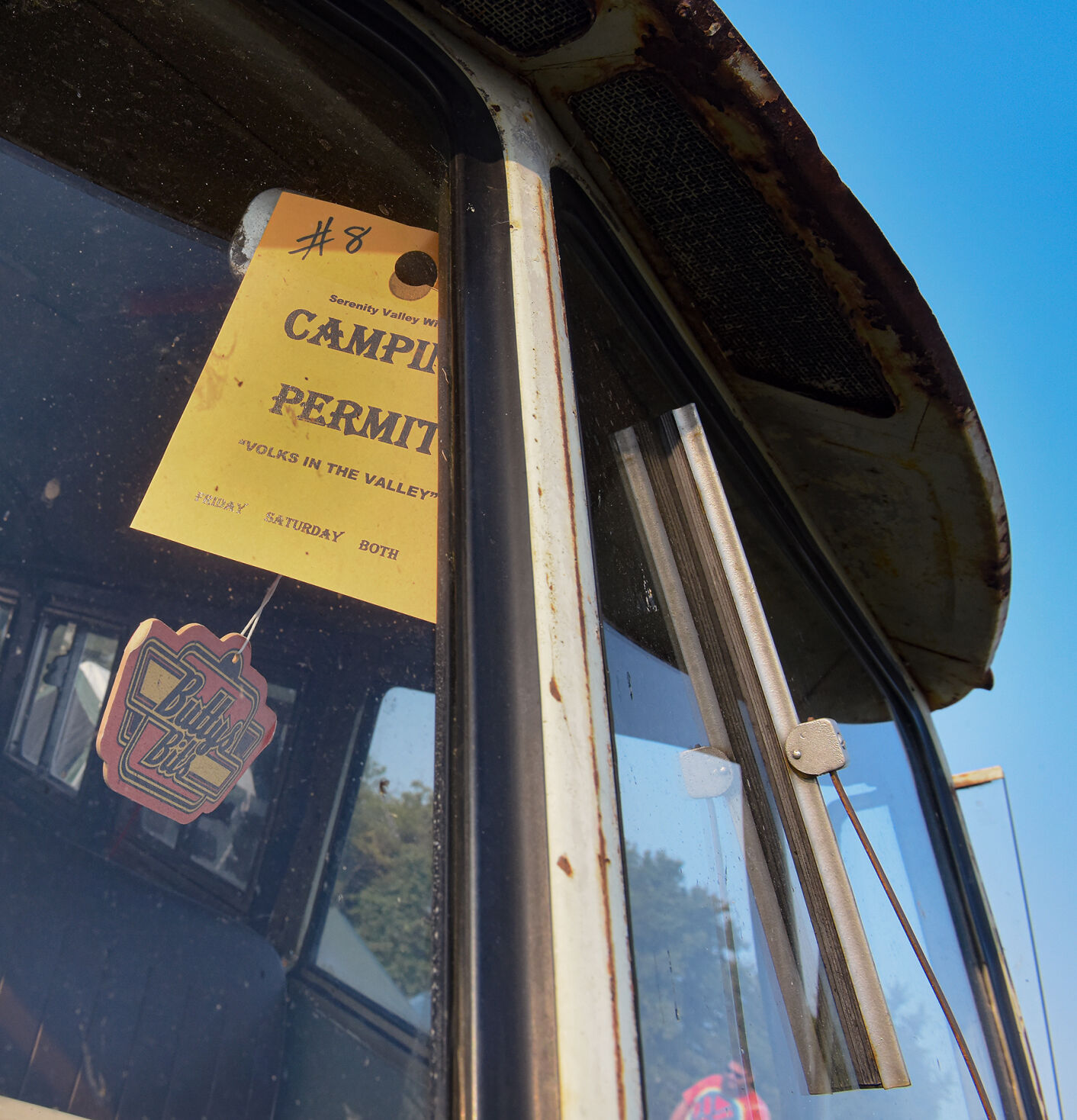 A camping permit hangs from the windshield of a Volkswagen